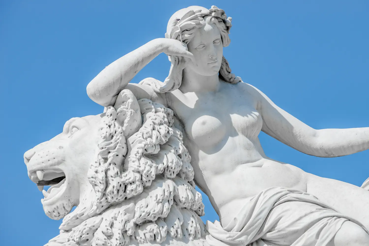 Cosmopolitan Aesthetics Hannover und Braunschweig - Antike Statue einer sinnlichen Frau aus der Renaissance, die auf einem großen Löwen in Potsdam, Deutschland, liegt.
